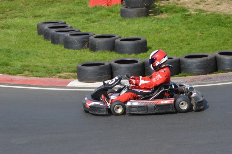 Kart racing past stacks of tyres