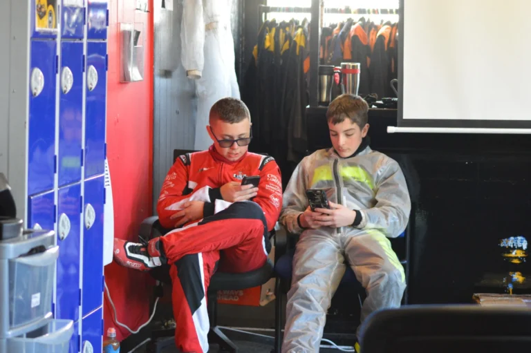 Samuel and a friend relaxing in the garage in race suits