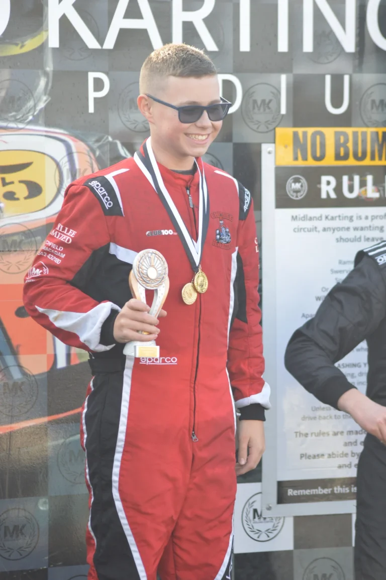 Samuel wearing his medal on the podium